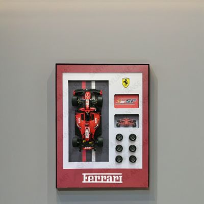 Специализированный спортивный автомобиль Porsche и красивые модели домов выставлены в стенной раме для модного домашнего декора